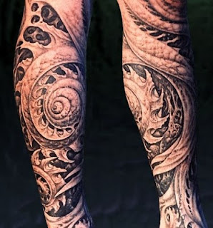 biomechanic tattoo on the leg: alien-like tentacles