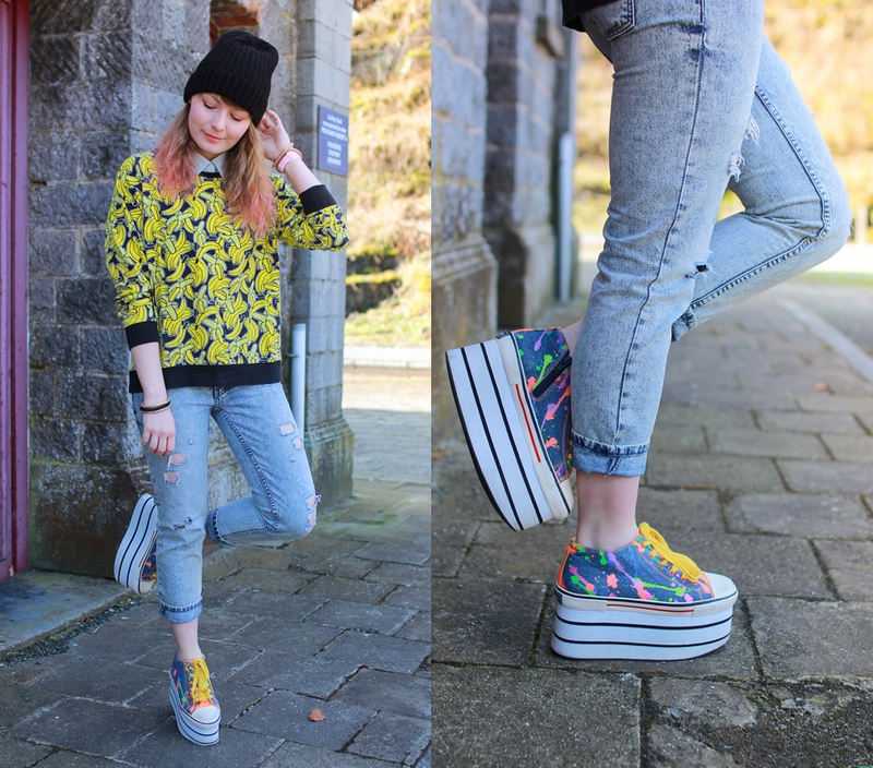 Tenue avec un pull imprimé banane, un jeans troué et des chaussures à plateformes multicolor