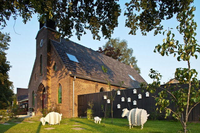 Picture of the church and sheep sculptures on the grass as seen from the street