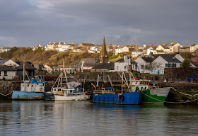 Photo of fishing boats in the harbour with Christ Church, Maryport, in the background