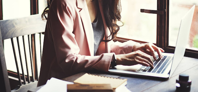 Business woman sitting at desk working on laptop