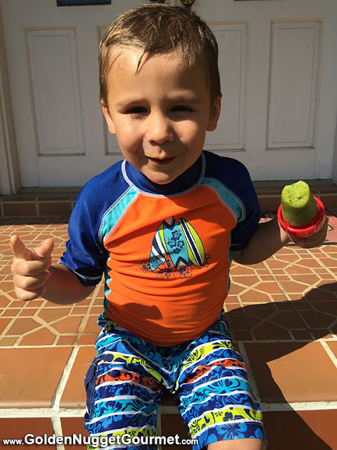 Little boy sitting and holding a popsicle