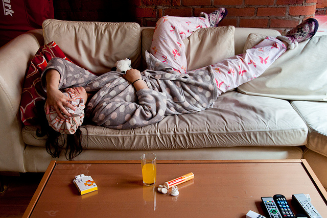 Photograph of woman lying on a couch with a hangover