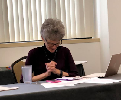 a light-skinned woman with hands folded in prayer