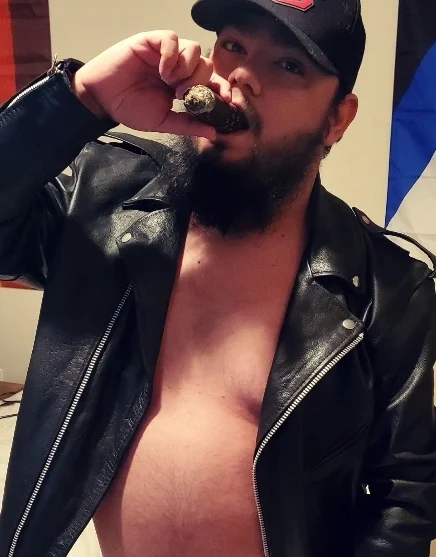 Black leather biker jacket on bearded sexy bear smoking cigar named Cubsmoke