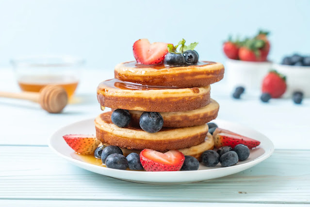 Pancakes with Caramel Strawberries Blueberries and Honey