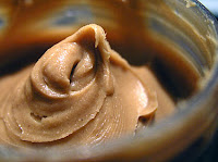 A Swirl of Peanut Butter with small chunks of peanuts visible.