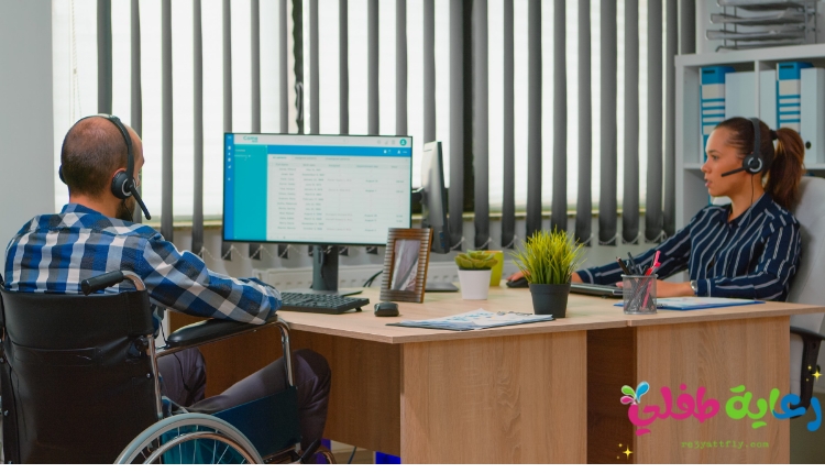 صورة تحتوى على شخصين من فريق عمل واحد أحدهم من ذوي الاحتياجات الخاصة (رجل جالس على كرسي متحرك)، تعبر الصورة عن حقوق ذوي الاحتياجات الخاصة في العمل.
