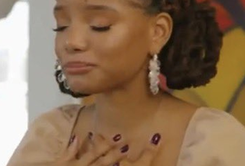 Halle of Chloe x Halle with her hands on her chest as she holds back tears.