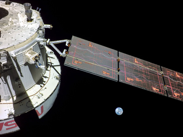 A snapshot of NASA's Orion spacecraft with Earth floating in the distance.