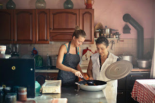 Two women cooking together in a kitchen.