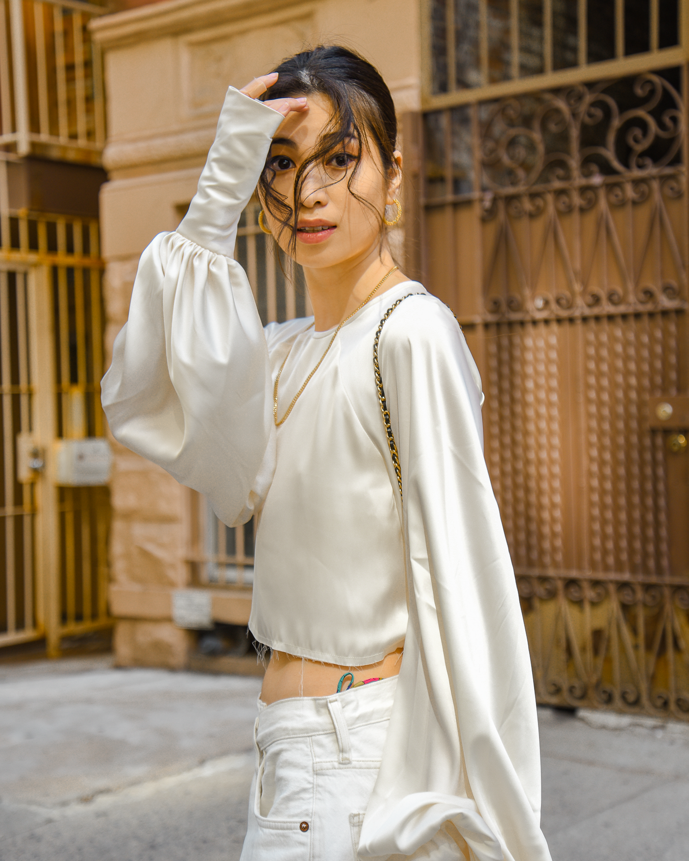 Orseund Iris Drama Cropped Satin Blouse in cream with AgoldE cross-over denim and sneakers casual style in Upper West Side New York City - FOREVERVANNY.com