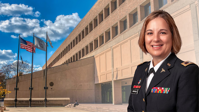 Col. (Dr.) Ashley Maranich with the brick facade of USU as a background.