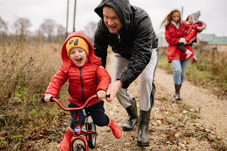 A father teaching a child how to ride a bike