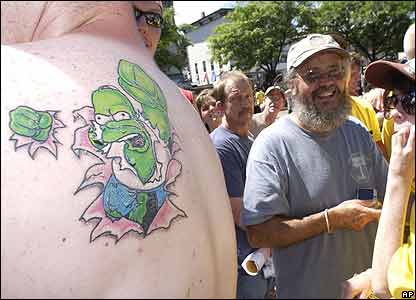 tribal sun tattoo wrapped around a bart simpson tattoo