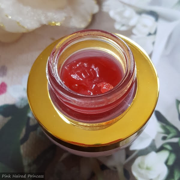 red coloured skincare balm inside jar