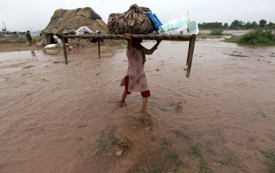 An Indian villager carrying her belongings during flash flood