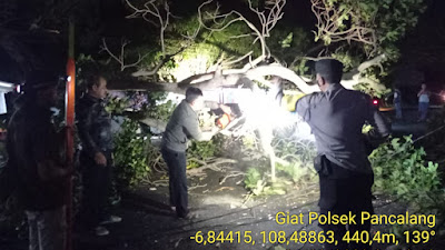 Patroli Malam Polsek Pancalang Membantu Masyarakat Dalam Membersihkan Pohon Tumbang yang Menghalangi Jalan