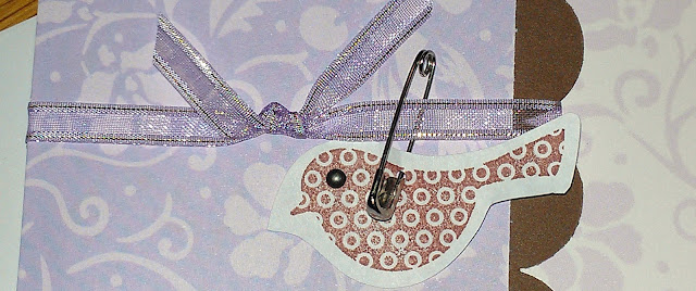 Close-up of bird, safety pin and ribbon detail