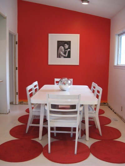 Elegant-modern-interior-design-dining-room-with-white-dining-table-white-chairs-red-circles-rug-red-and-white-walls-and-picture