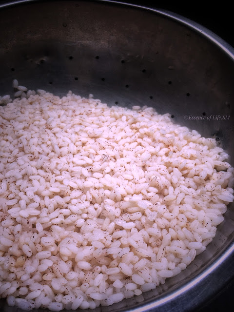 Steaming hot cooked Kerala Matta rice in a colander after draining.