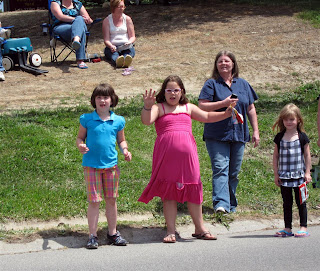 big girl excited about getting candy thrown at parade, ripped dress