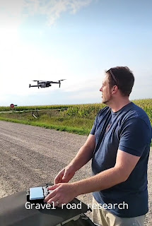 A photograph of Will Gast piloting a drone on a gravel road. Text on the image reads "Gravel Road Research."