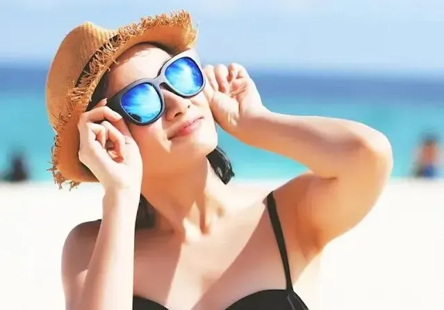 A Woman on a beach wearing sunglasses