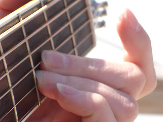 Fingers, guitar fretboard, chord.