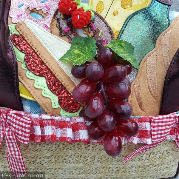 close up of grape and sandwich applique on front of handbag