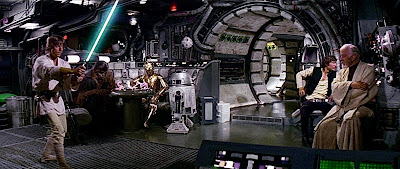 Luke practices with his lightsaber, Chewbacca, C-3PO, and R2-D2 play space chess, Han solo looks away and obi-Wan concentrates in a scene from a new hope.