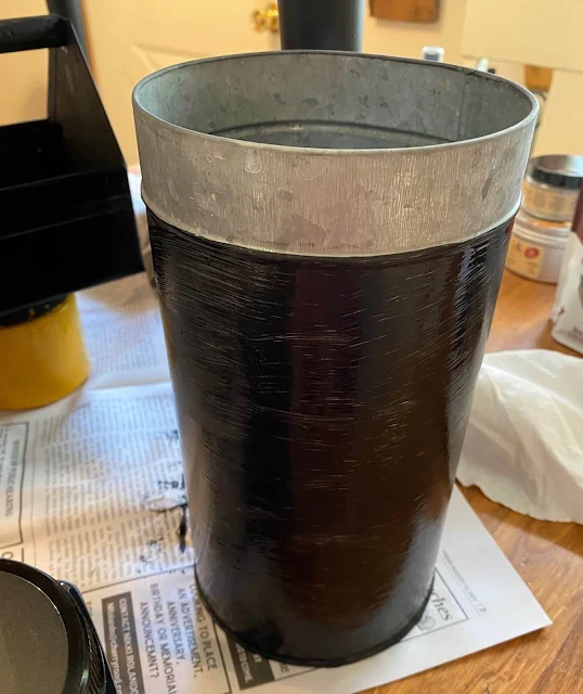 Photo of a galvanized canister bottom being painted black.