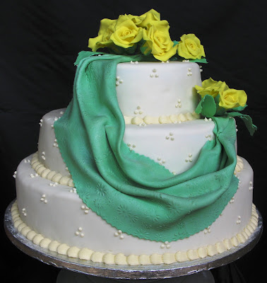 This threelayer wedding cake with yellow roses was made for a couple