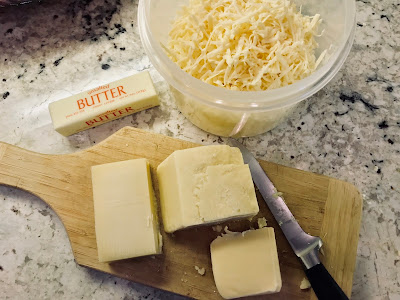 Photo of ingredients of butter and cheese for recipe on a cutting board