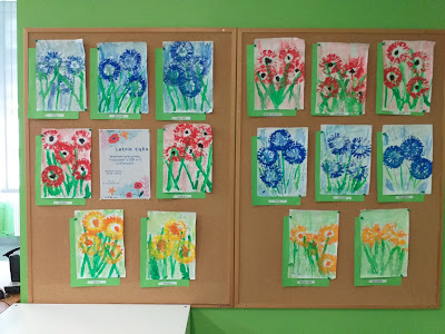Wystawa prac przedszkolaków przedstawiająca kwiaty.