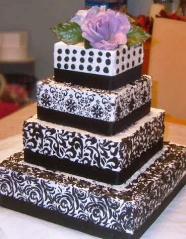 Exquisite four tier highly patterned black and white wedding cake with light