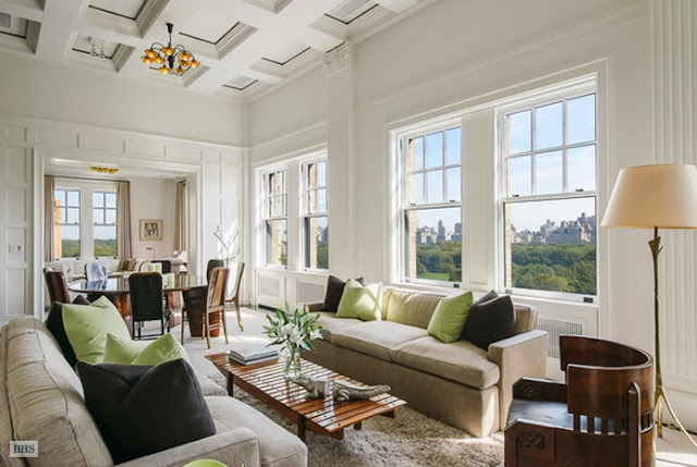 Living room in a New York penthouse with dueling sofas, a shag rug, large windows with a view of Central Park and coffered ceiling