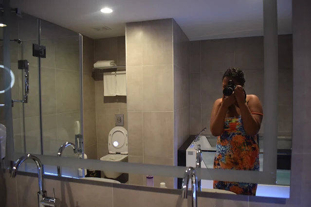 "Shachem Lieuw taking a picture in the bathroom of Yogh Hospitality Hotel in Paramaribo"