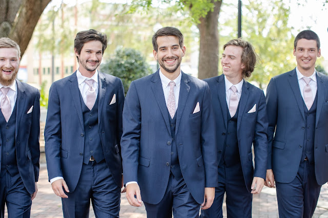 groom and groomsmen in navy suit with pink ties