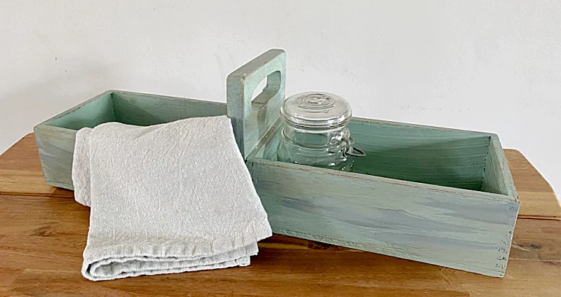 green crate with towel and jar
