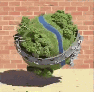 3D model globe earth magically spinning above sidewalk in front of brick wall with cars and planes buzzing around trees buildings a river wraps around making a pattern like a tennis ball