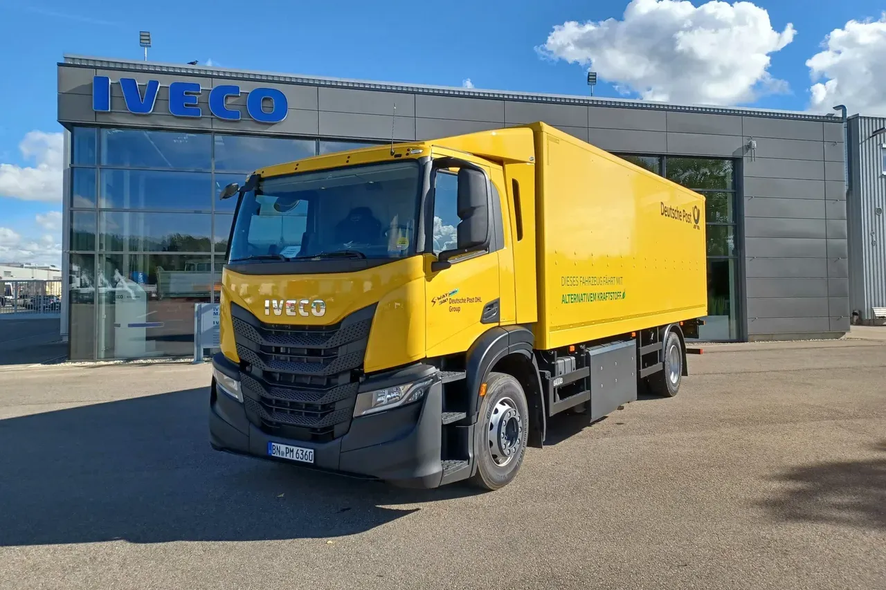 Caminhao Iveco amarelo na frente de um predio