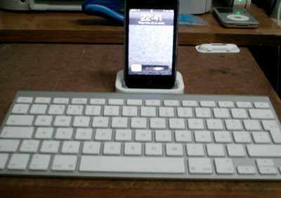 foto que mostra um teclado qwerty wireless e um iPhone 3GS