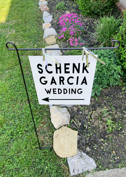 Wedding Venue Direction Sign hanging from garden flag holder.