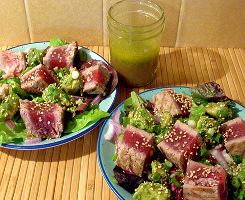 Two Plates of Salad with Side of Dressing