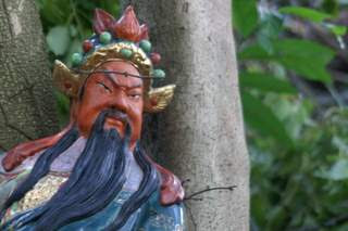 Image of a ceramic protective deity in the forest of Hong Kong