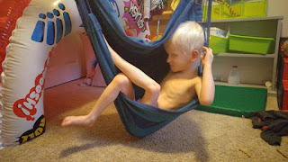 Orion sits in a sky hammock swing chair