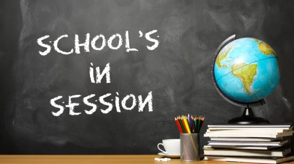 Chalk on blackboard reading "School in session" - "N"s written backward