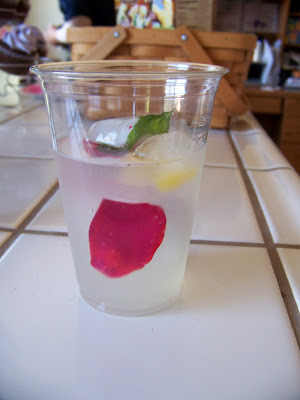 Mint leaves and rose petals in ice cubes in lemonade