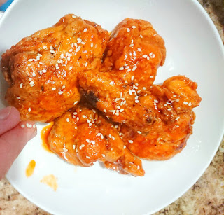 sprinkling sesame on homemade bbq sauce coated chicken